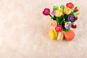 top-view-french-macarons-with-flowers-pink-table-cake-biscuit-sugar-sweet (1)